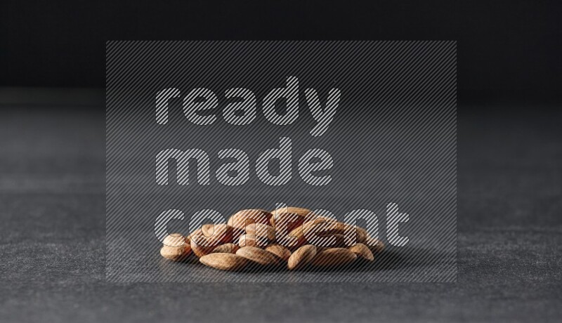 A bunch of peeled almonds on a black background in different angles