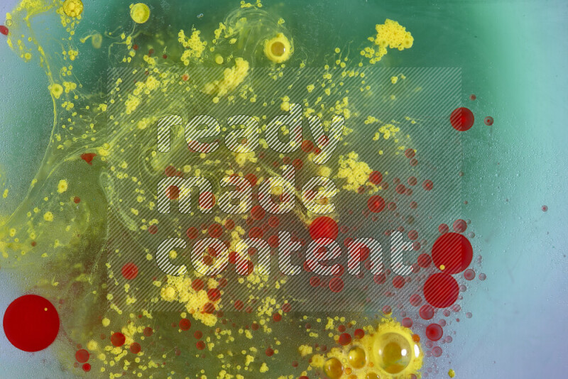 The image captures a dramatic splatter of red, green and yellow paints over the backdrop