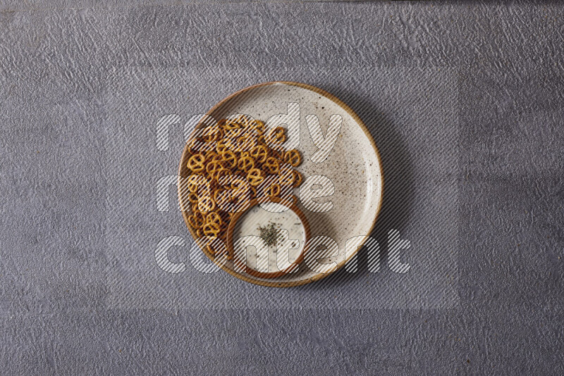 Assorted snacks in pottery bowls on grey background