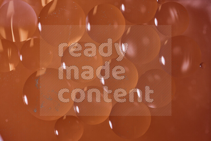 Close-ups of abstract oil bubbles on water surface in shades of orange