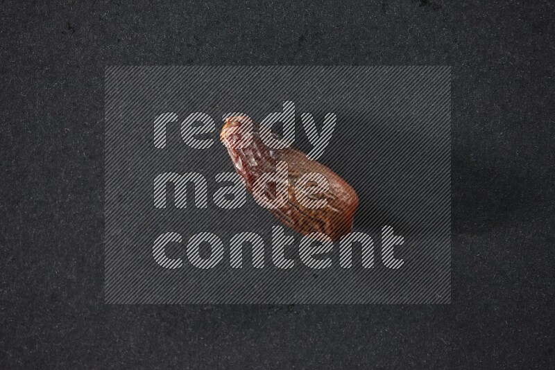 حبة واحدة من البلح المجفف علي خلفية سوداء