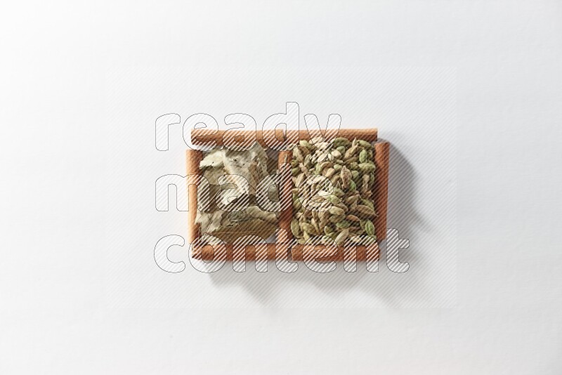 2 squares of cinnamon sticks full of cardamom and bay laurel leaves on white flooring
