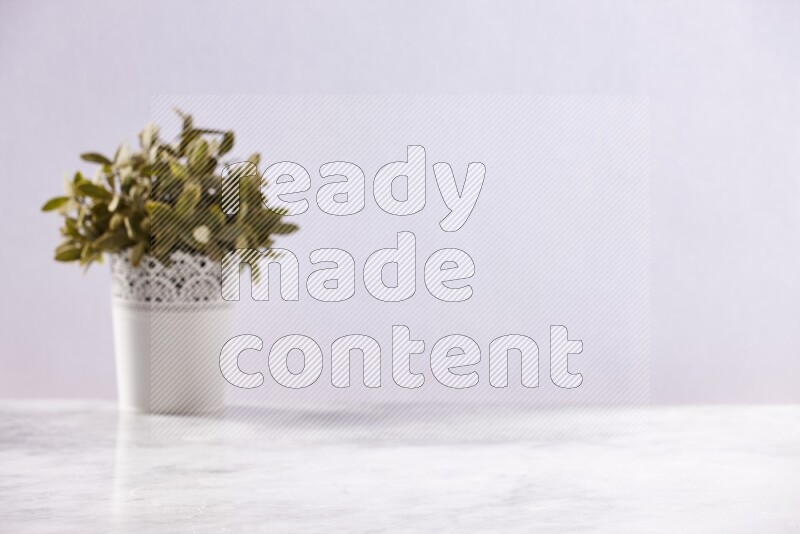 Artificial plant in white decorative pot on grey marble background