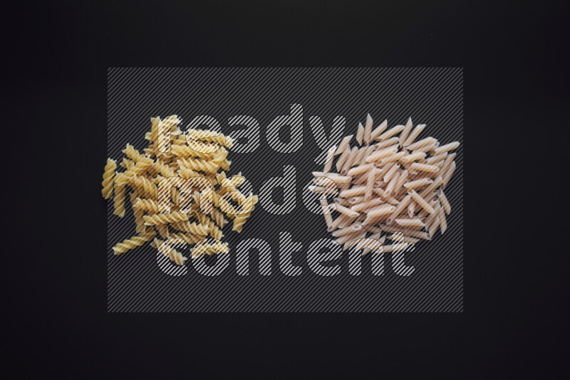 Different pasta types in bunches on black background