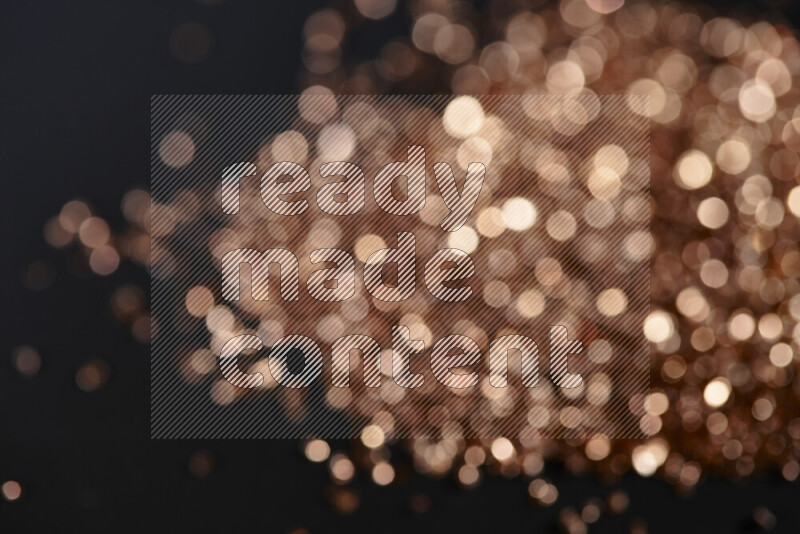 قطع زجاجية برونزية لامعة متناثرة على خلفية سوداء