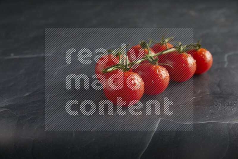 Red cherry tomato vein on a textured black slate background 45 degree