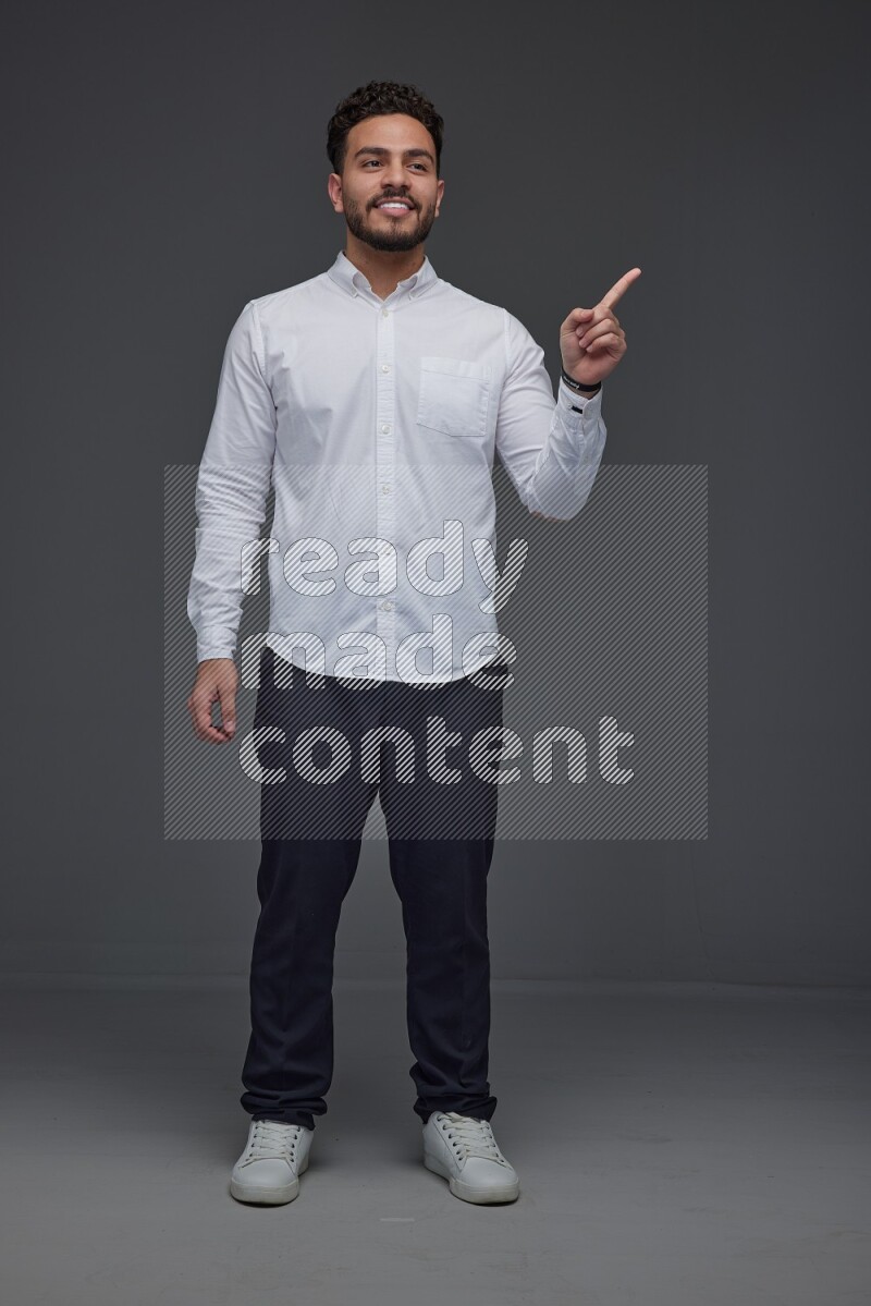 A man wearing smart casual standing and making multi hand gestures eye level on a gray background