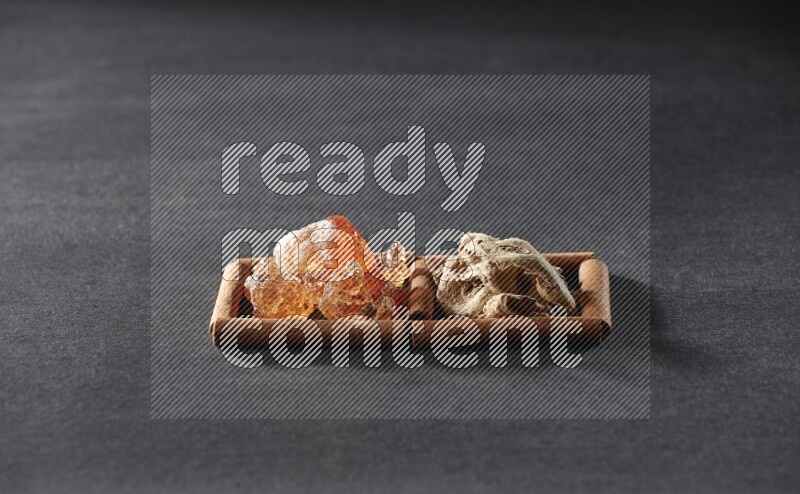 مربعان من أعواد القرفة ممتلئان بالزنجبيل المجفف والصمغ العربي علي خلفية سوداء