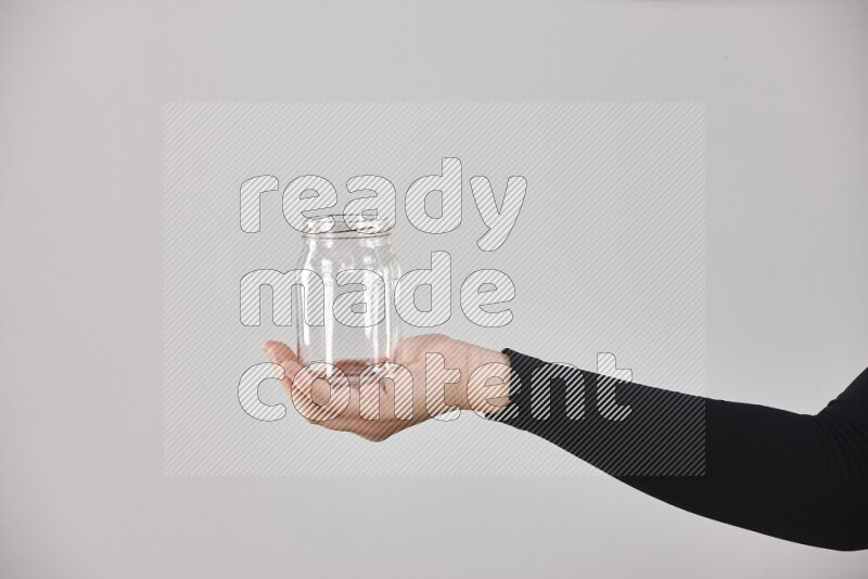 A woman in black abaya holding different glassware in different positions