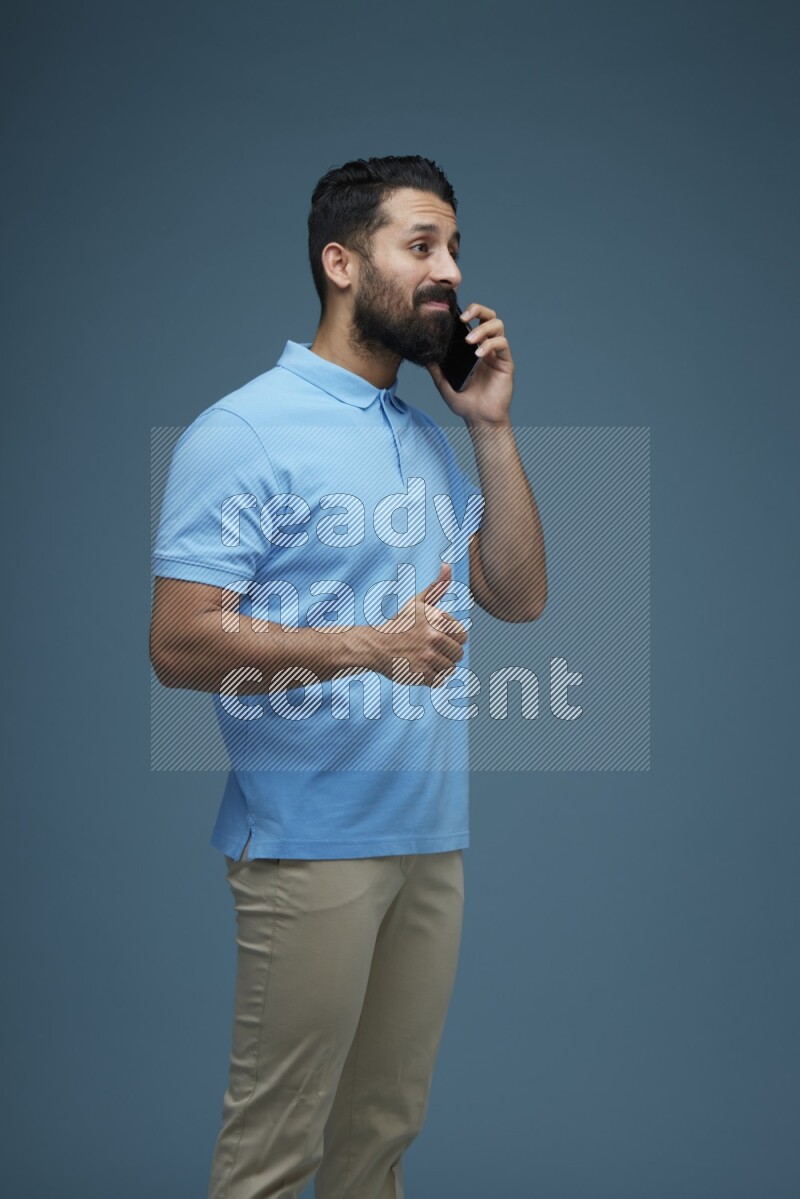 A man having a Call in a blue background wearing a Blue shirt
