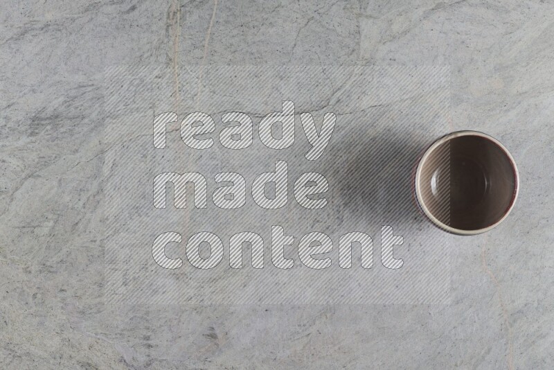 وعاء فخاري متعدد الألوان على خلفية من الرخام الرمادي