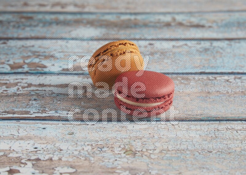 45º Shot of of two assorted Brown Irish Cream, and Red Velvet macarons on light blue background