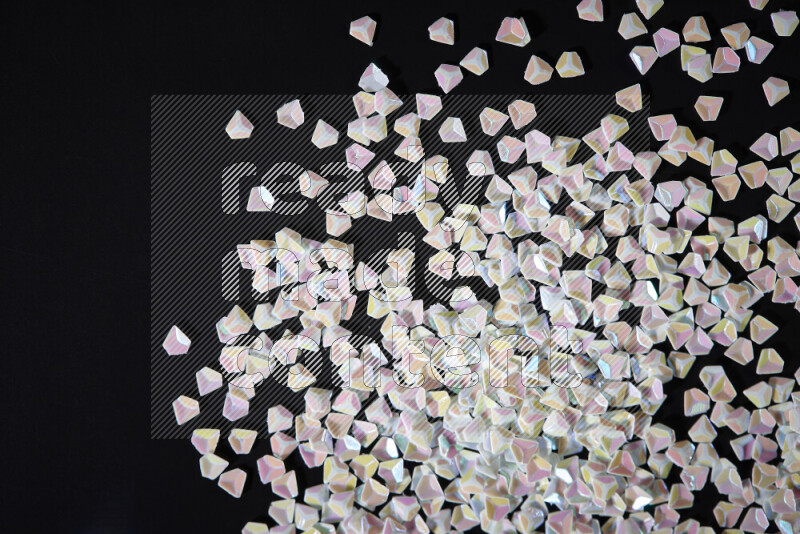 Colorful plastic shards for decoration scattered on a black background