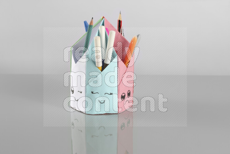Origami pen holder on grey background