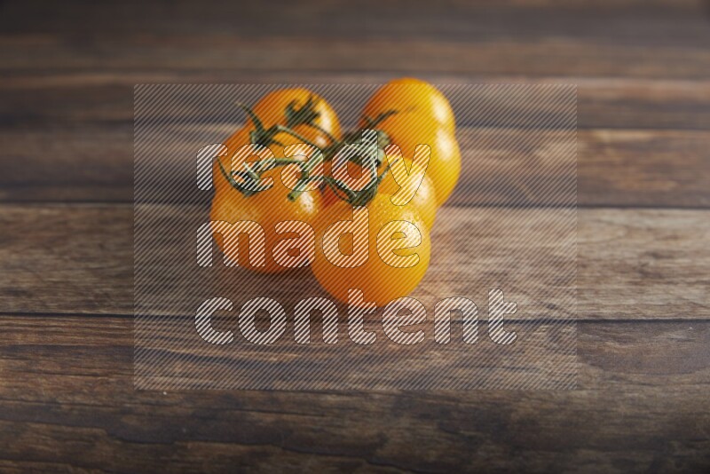 yellow cherry tomato vein on a textured wooden background 45 degree