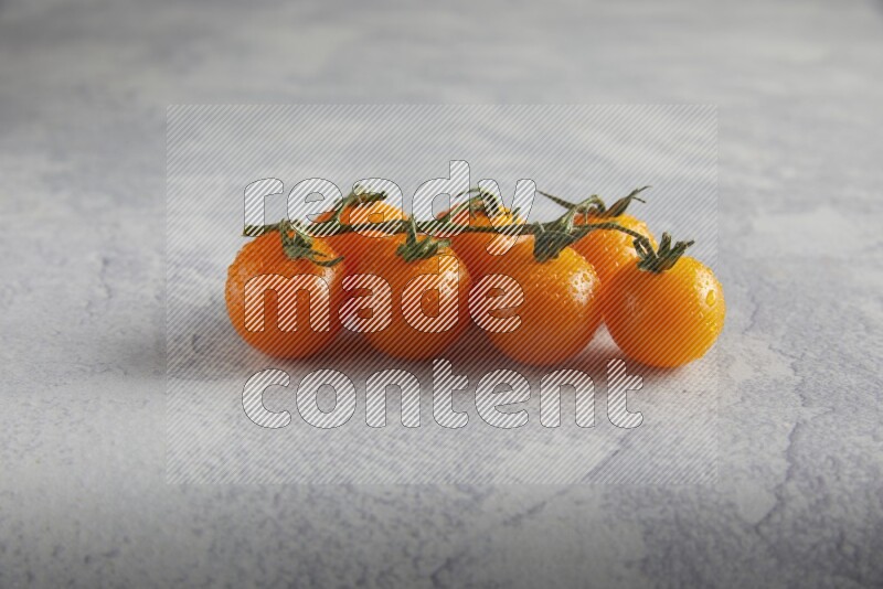 Orange cherry tomato vein on a light grey textured background 45 degree
