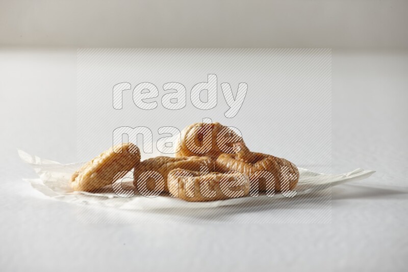Dried figs on a crumpled piece of paper on a white background in different angles
