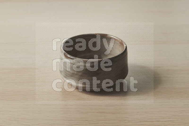 A multicolored pottery bowl on light wooden background