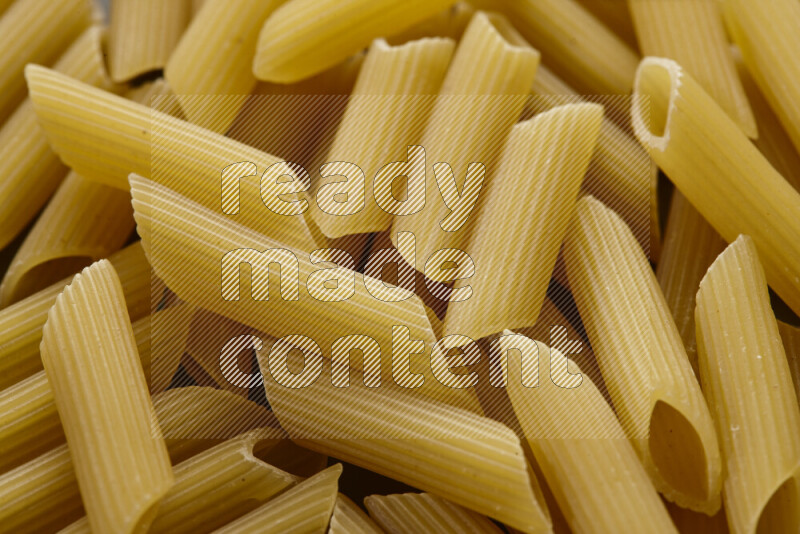 Penne pasta on grey background