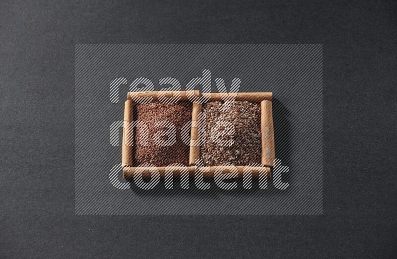2 squares of cinnamon sticks full of garden cress and flaxseeds on black flooring