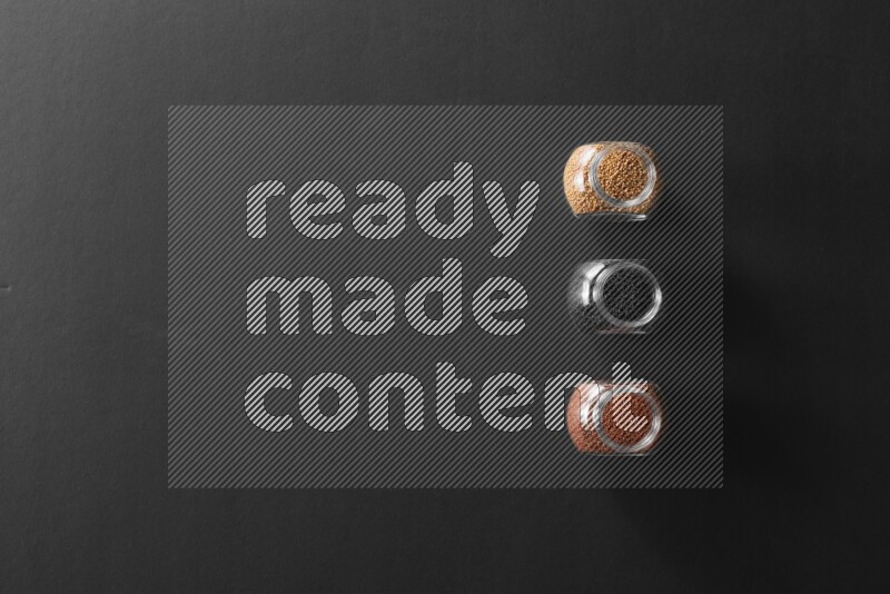 حبوب الخردل و حب الرشاد وحبة البركة في أوعية زجاجية علي خلفية سوداء