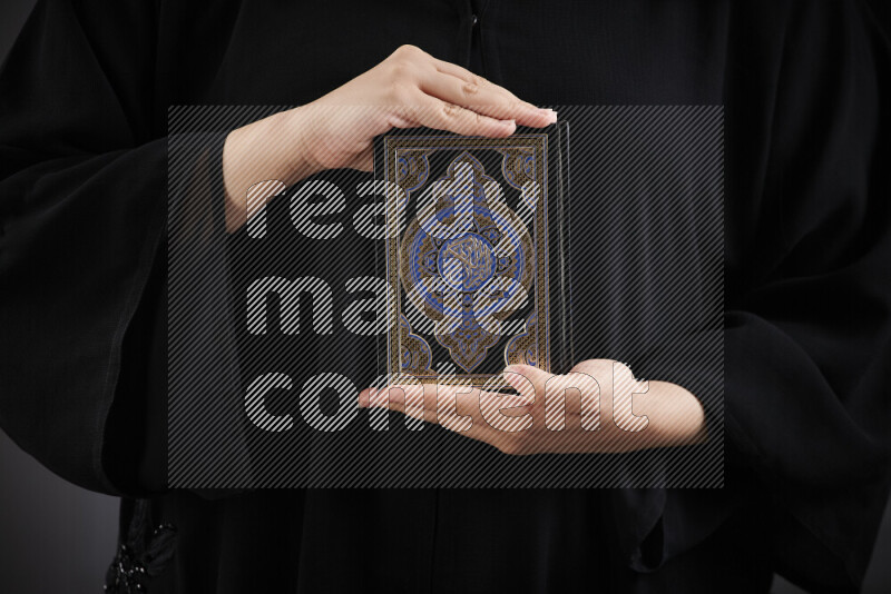 امرأة تحمل بيديها مصحف القرآن في أوضاع متعددة