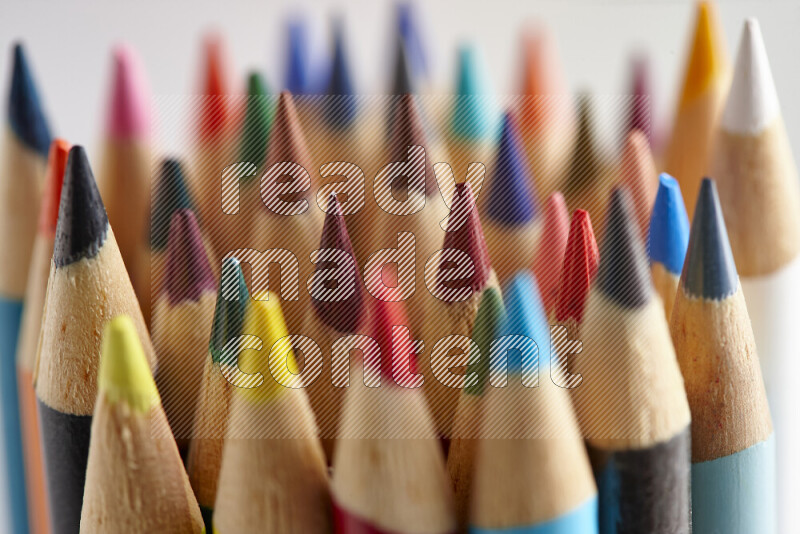 The image captures a close-up of sharpened colored pencils on multicolored background