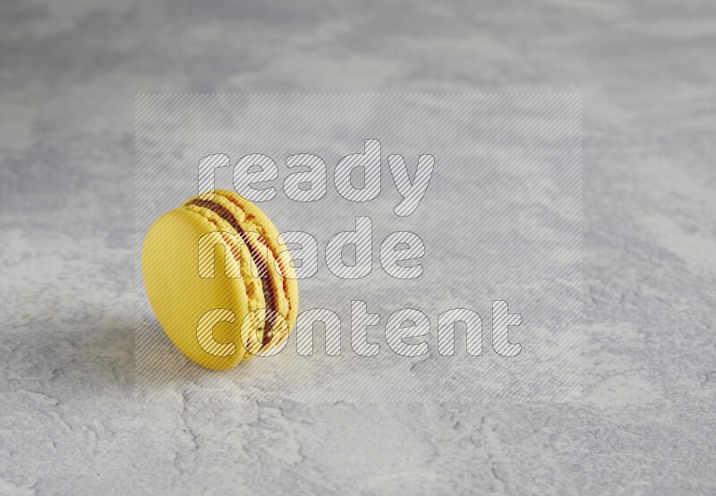 45º Shot of Yellow Lemon macaron on white  marble background