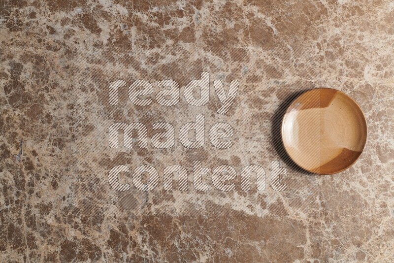 A multicolored pottery plate on beige marble background