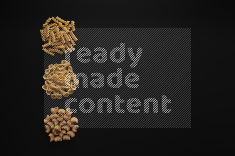 Different pasta types in 3 bunches on black background