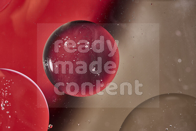 Close-ups of abstract oil bubbles on water surface in shades of red and brown