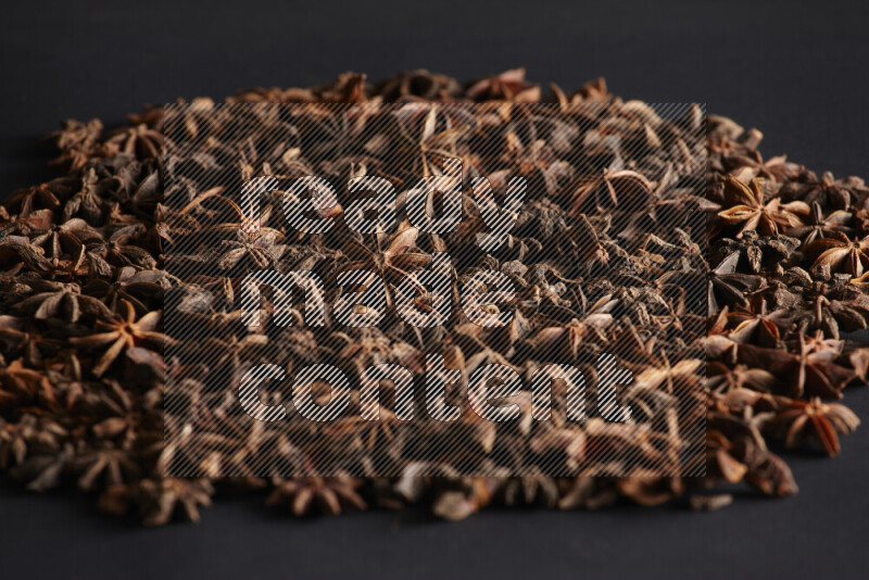 Star Anise fill the frame on black flooring