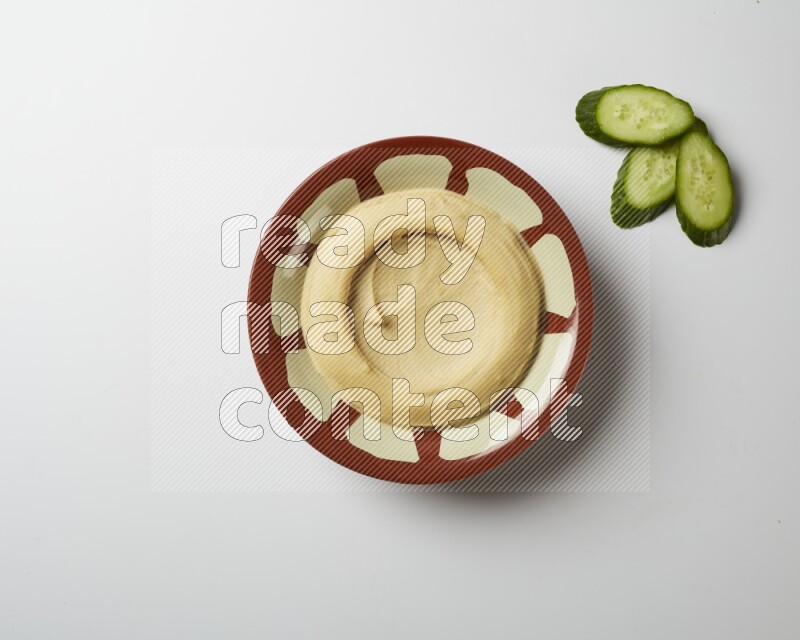 Plain hummus in a traditional plate on a white background