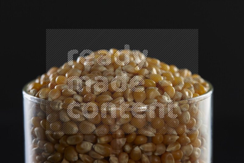 Pop corn in a glass jar on black background
