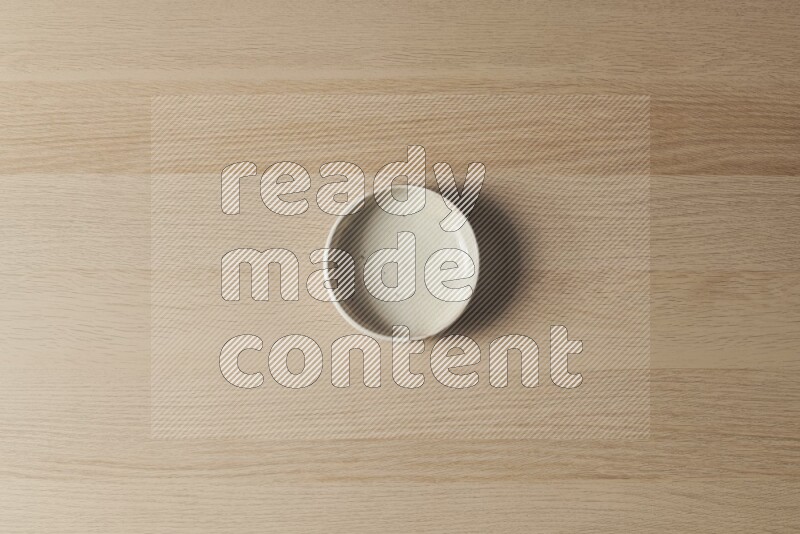 A white pottery bowl on light wooden background