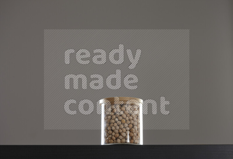 Chickpeas in a glass jar on black background