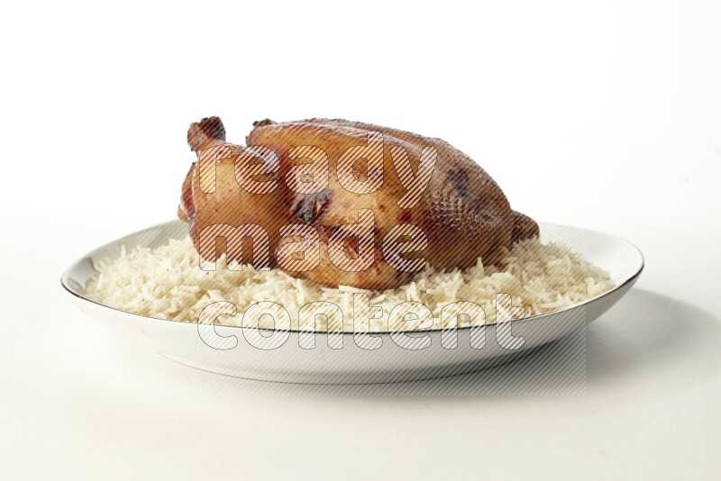 white  basmati Rice with  whole roasted chicken  on a white plate with a silver rim direct  on white background