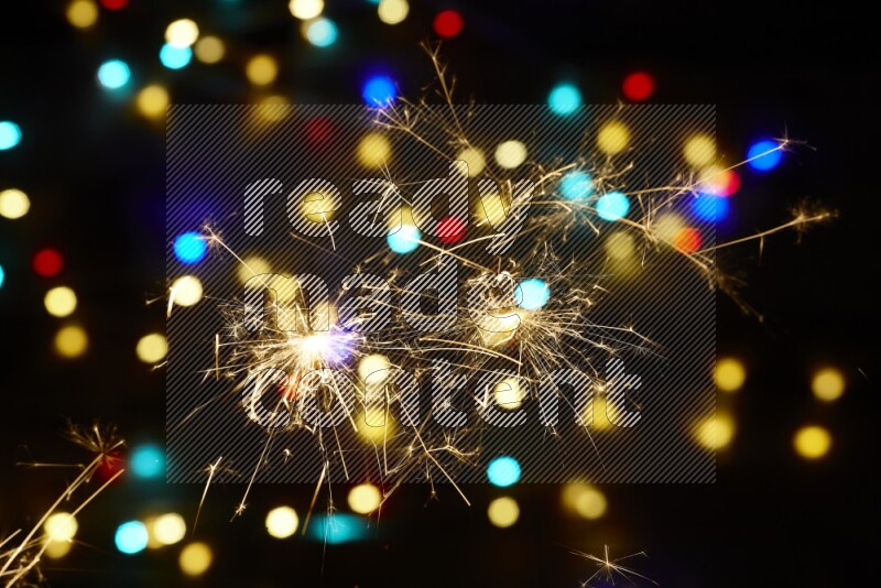 Sparkler candles with multicolored light bokeh background