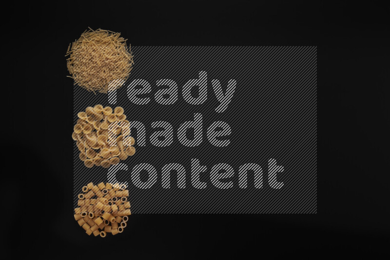 Different pasta types in 3 bunches on black background