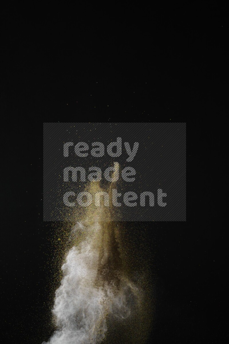 A side view of brown powder explosion on black background