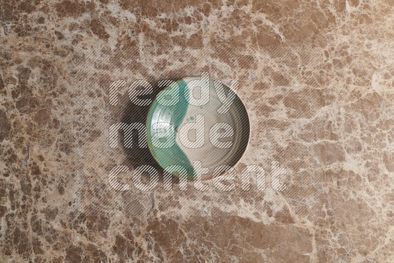 A decorative pottery plate on beige marble background