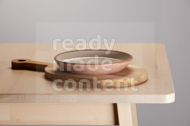 multi colored plate placed on a  wooden oval cutting board on the edge of wooden table