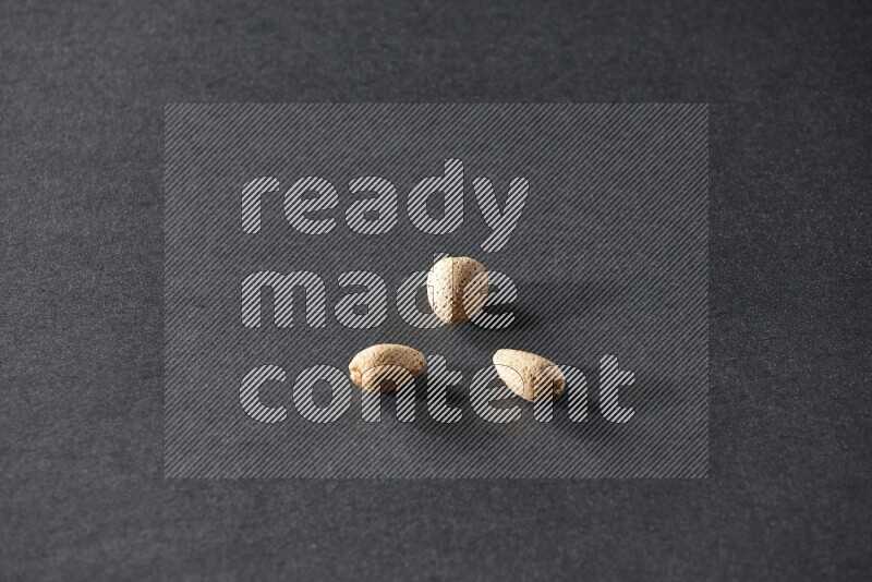 3 almonds on a black background in different angles
