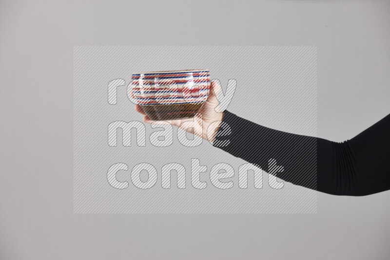 A woman in black abaya holding different pottery essentials in different positions