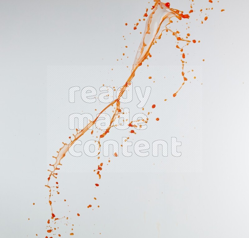 Orange liquid splash and drops on white background