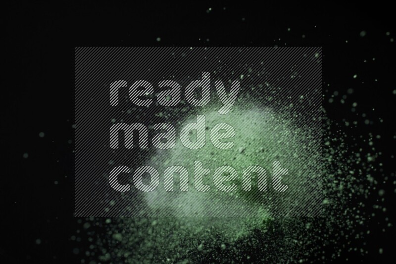 Green powder explosion on black background