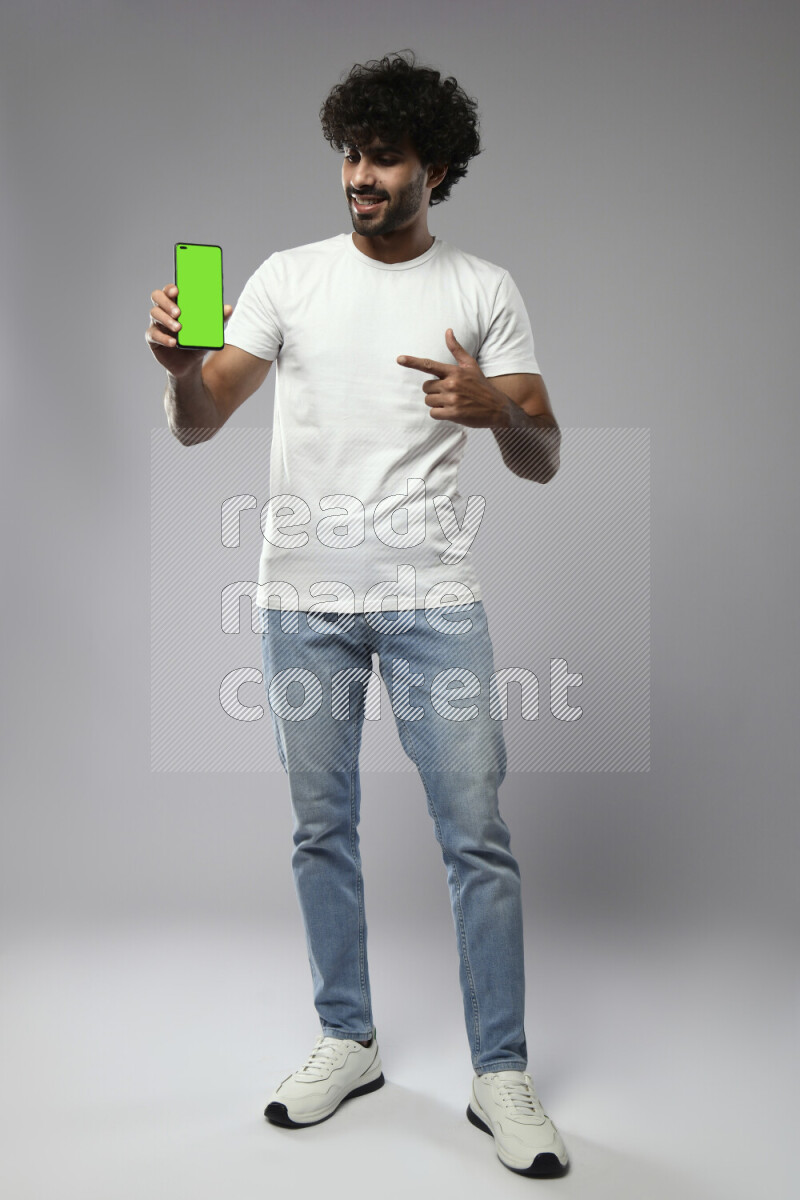 A man wearing casual standing and showing a phone screen on white background