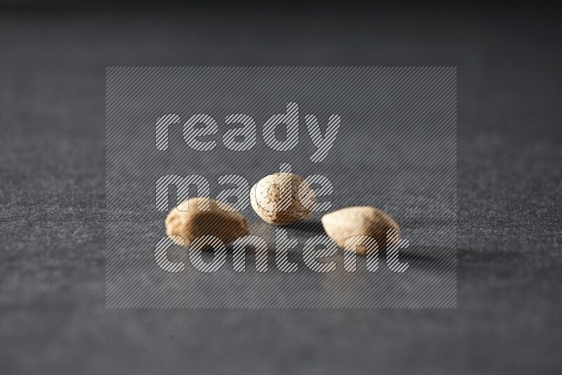 3 almonds on a black background in different angles