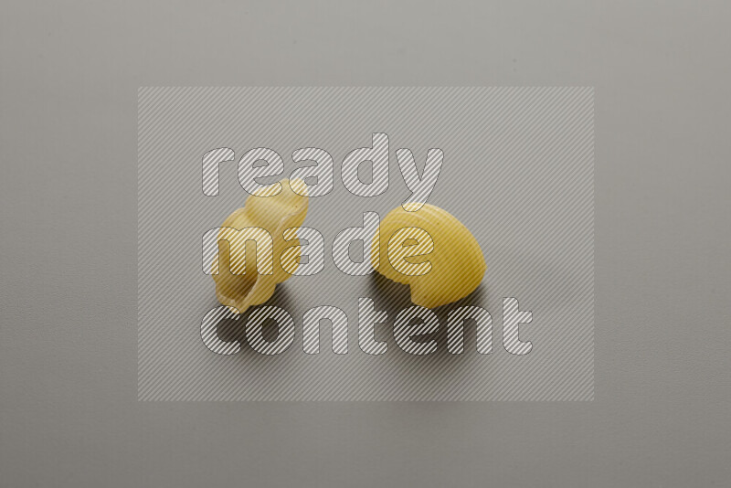 Snails pasta with other types of pasta on grey background