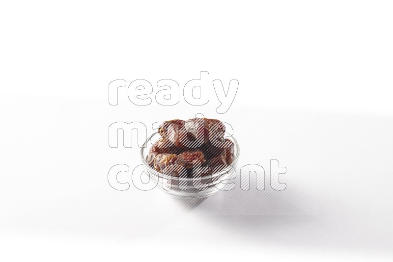 Dates in a glass bowl on white background